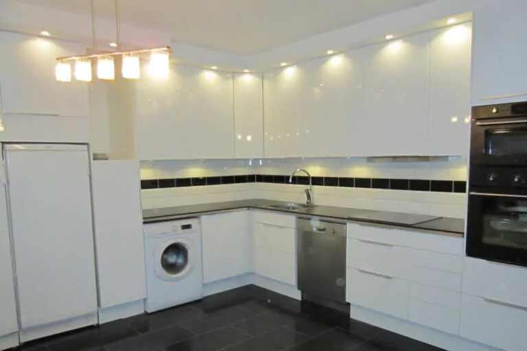 Ett vitt kök med mycket lampor